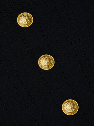 Close-up of three ornate gold crest buttons arranged vertically on the black sculpting stretch knit fabric of the Sasha Top by L'AGENCE, featuring subtle stitched lines.