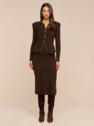 A woman stands facing forward against a plain beige background, wearing the Melissa Knit Cardigan in brown paired with a matching mid-length skirt and dark brown knee-high boots.