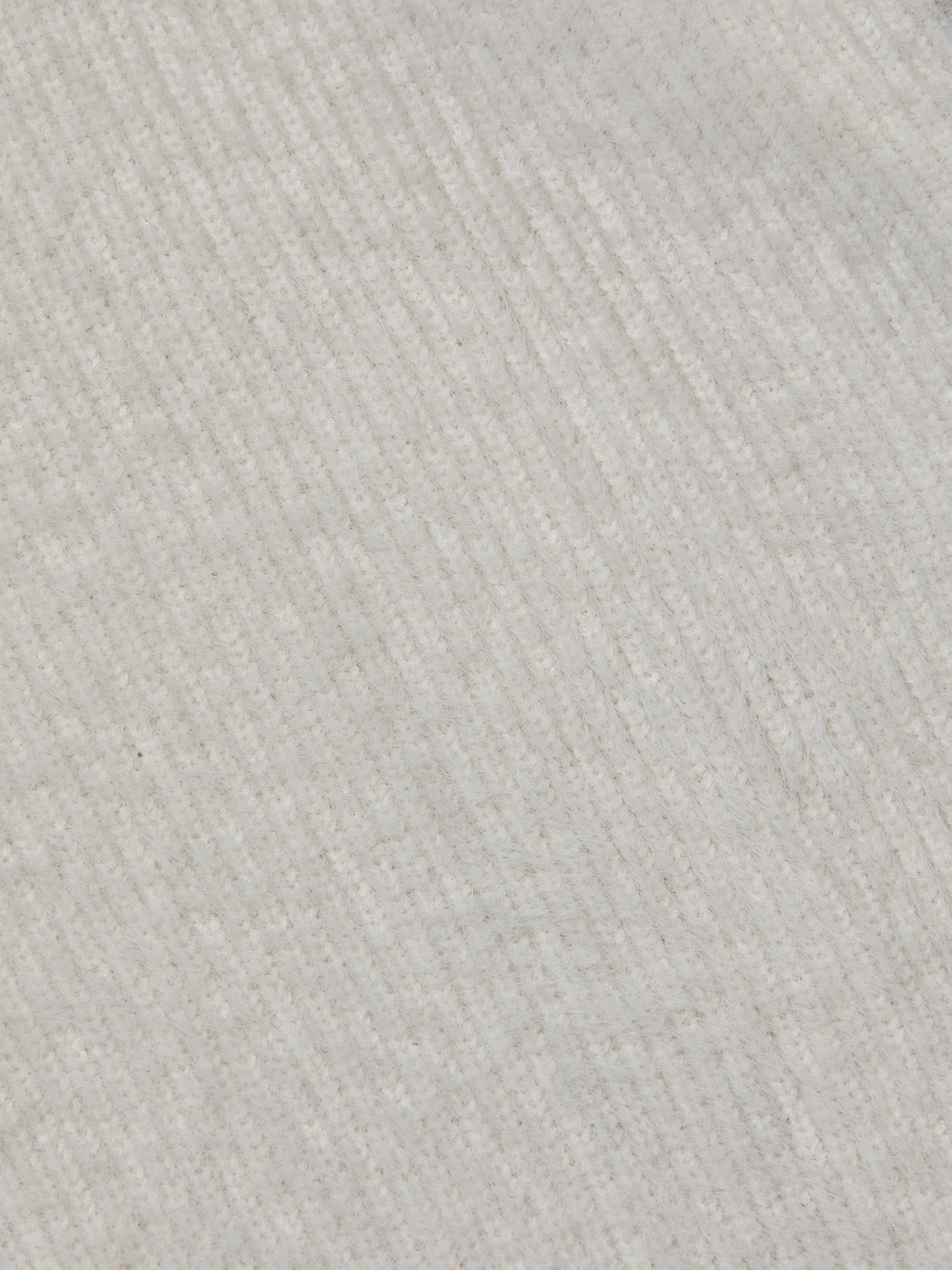 Close-up of the Guinevere Cropped Pullover’s ultra soft knit fabric, featuring diagonal ribbed lines that create a subtle pattern across the surface. The material appears cozy and plush.