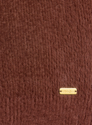 A close-up of a textured brown ultra soft knit fabric with a small rectangular gold label that reads LARSNOC, attached near the bottom right corner—perfectly capturing the cozy feel and premium touch of the Guinevere Cropped Pullover.