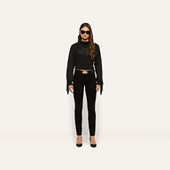 A person wears a marled black Maddison Turtleneck with a cropped turtleneck, fringe sleeves, and a corset-style bodice, paired with slim-fit pants, a belt with a gold buckle, and black heels.