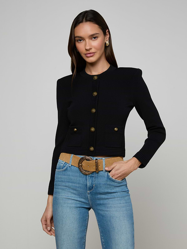 Woman wearing the Patsy Cropped Cardigan, styled with light blue jeans and a tan belt, standing against a plain light background.