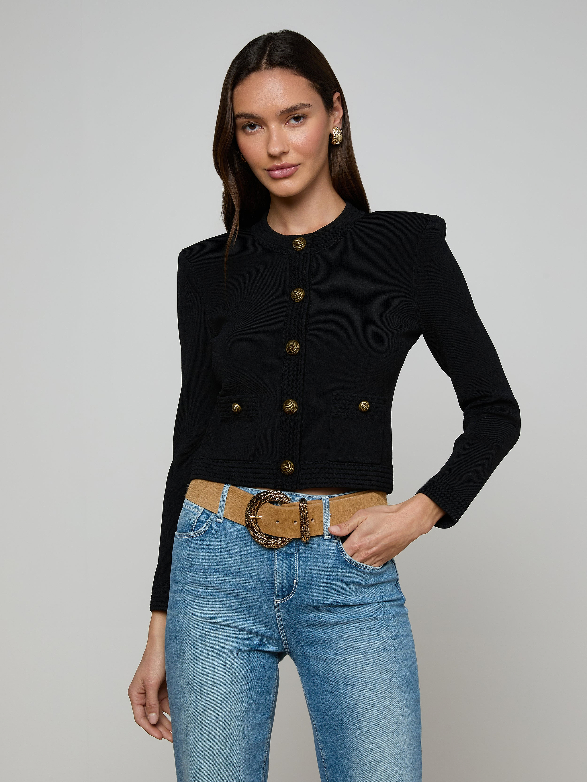 Woman wearing the Patsy Cropped Cardigan, styled with light blue jeans and a tan belt, standing against a plain light background.