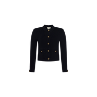 The Patsy Cropped Cardigan is a black, long-sleeve, collarless jacket crafted from power knit fabric. It features signature gold buttons down the front and on the cuffs, along with two front pockets. The cardigan is displayed against a plain white background.