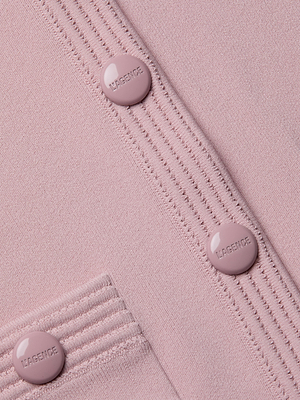 Close-up of the Patsy Cropped Cardigan in light pink pointelle knit, featuring ribbed detailing, three round L’AGENCE buttons, and a small pocket with coordinating ribbed trim.