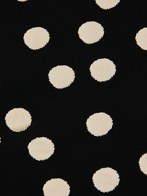 Close-up of Mae Knit Flare Skirt fabric in black jacquard, featuring evenly spaced, round white polka dots.