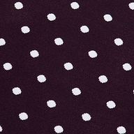 The Mae Knit Flare Skirt features white polka dots evenly spaced on a dark purple background, creating a playful and classic look.