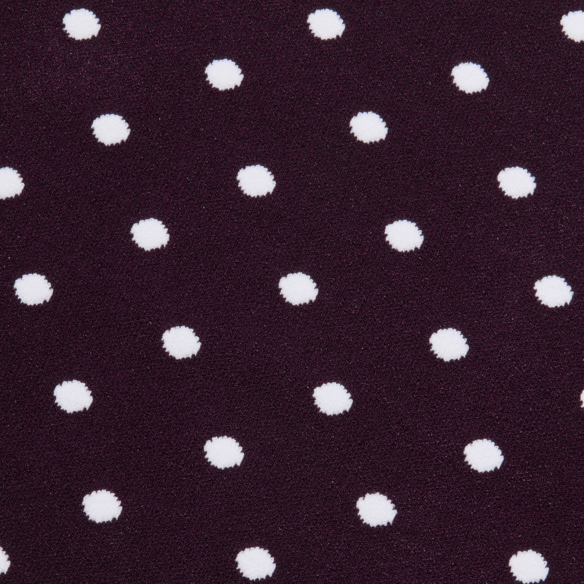 The Mae Knit Flare Skirt features white polka dots evenly spaced on a dark purple background, creating a playful and classic look.