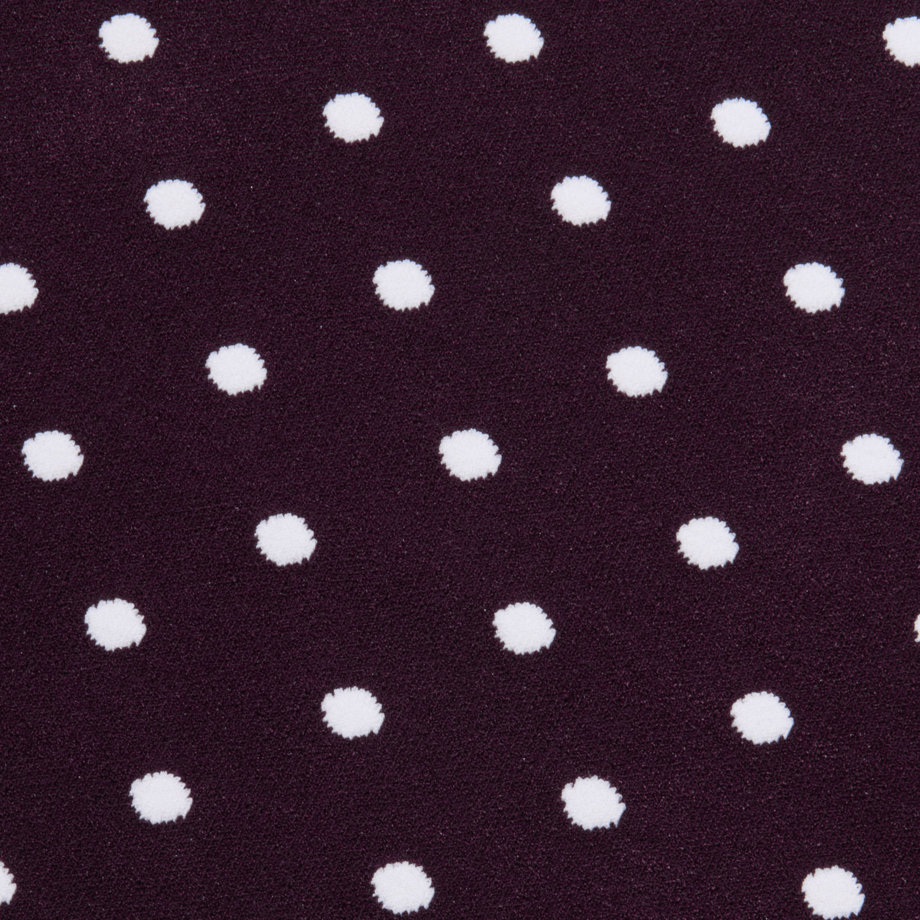 The Mae Knit Flare Skirt features white polka dots evenly spaced on a dark purple background, creating a playful and classic look.