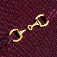 A close-up of a gold metal clasp connecting two ends of an adjustable purple strap, set against the textured stretch knit fabric of the Lana Flare Knit Dress.