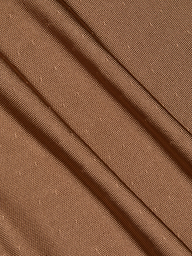 Close-up of the Lana Knit Dress in brown, showcasing textured fabric with diagonal folds and a subtle dotted pattern, evocative of elegant draping that adds depth and gentle movement.