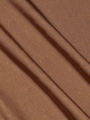 Close-up of Lana Knit Dress fabric in brown stretch knit, showing diagonal folds with a subtle dotted texture and a smooth, slightly shiny surface.