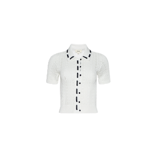 The Ninette Knit Top is a white short-sleeve pointelle knit cardigan, featuring a collar, front button closure, and black trim accents on the collar, placket, and sleeves for a touch of Parisian flair.