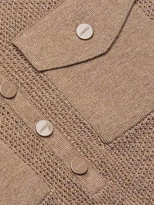 Close-up of the Carine Sweater, a textured beige lightweight knit with a utility pocket and round metallic buttons engraved with VERSACE JEANS COUTURE.