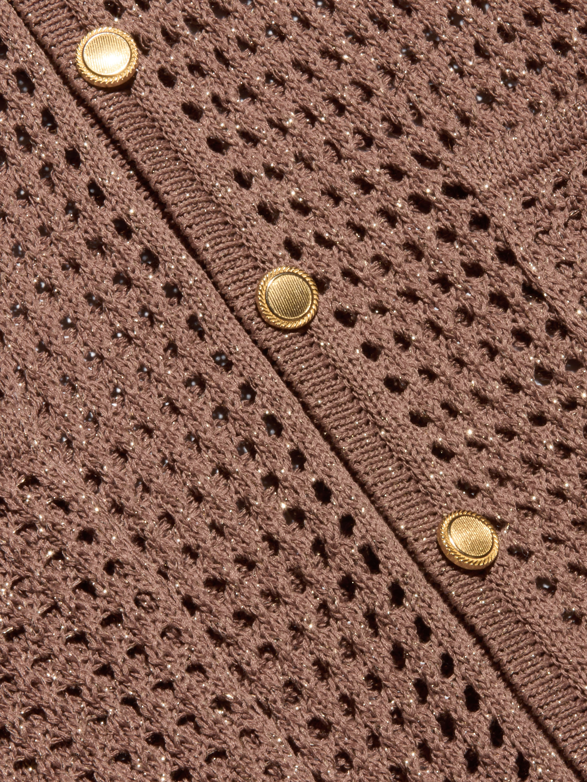 Close-up of the Mariana Pointelle Knit Shirt in brown, showcasing its airy, mesh-like pointelle pattern and a row of three round gold buttons along a ribbed edge.