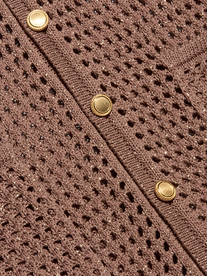 Close-up of the Mariana Pointelle Knit Shirt’s brown pointelle knit fabric, showing its textured openwork pattern and three gold-colored buttons on the ribbed edge—a stylish choice for your next vacation.