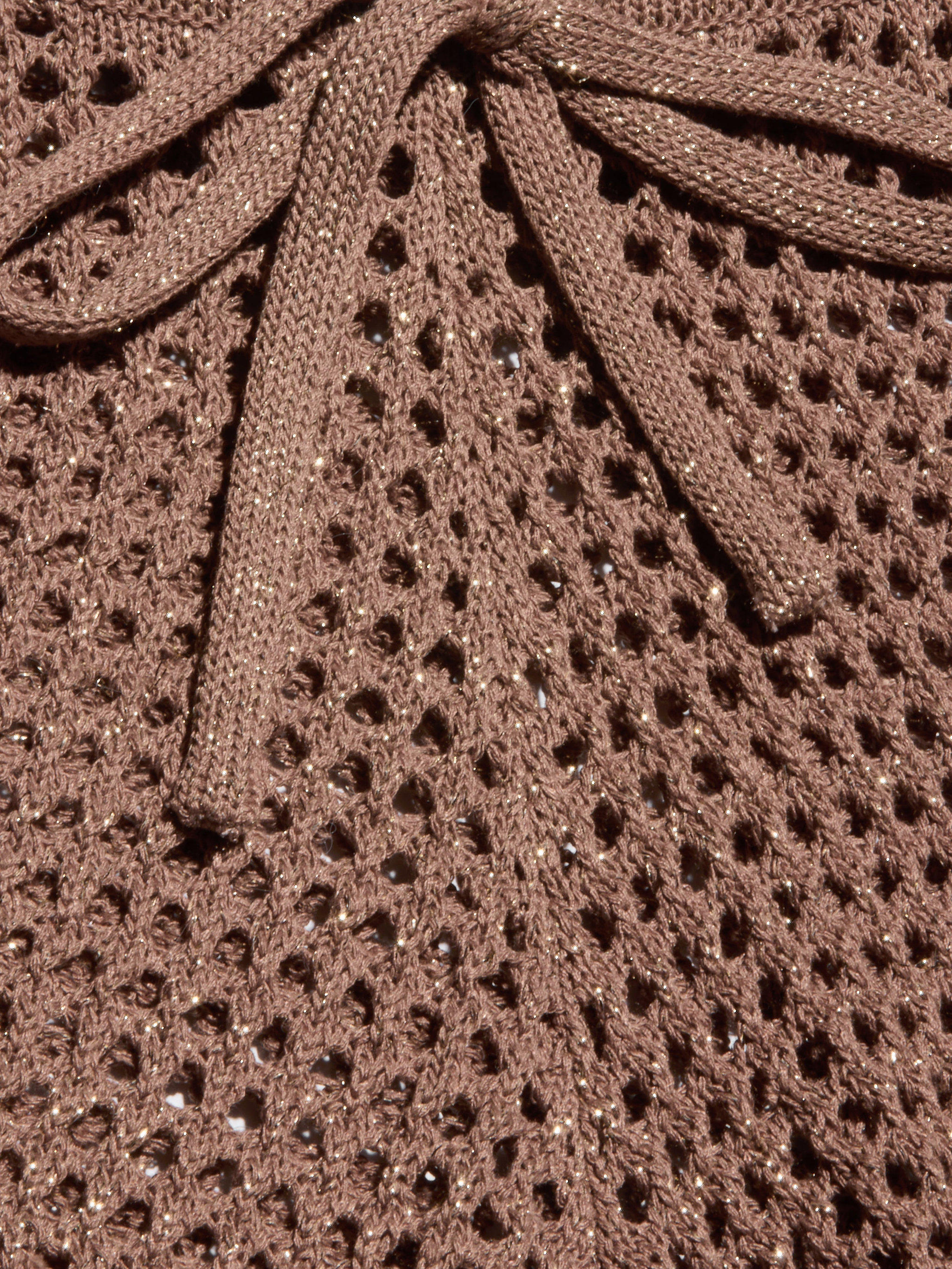 Close-up of the Solan Pointelle Knit Short in brown, featuring a glittery, net-like pointelle knit with shimmering threads woven throughout and a matching bow tied at the top center.