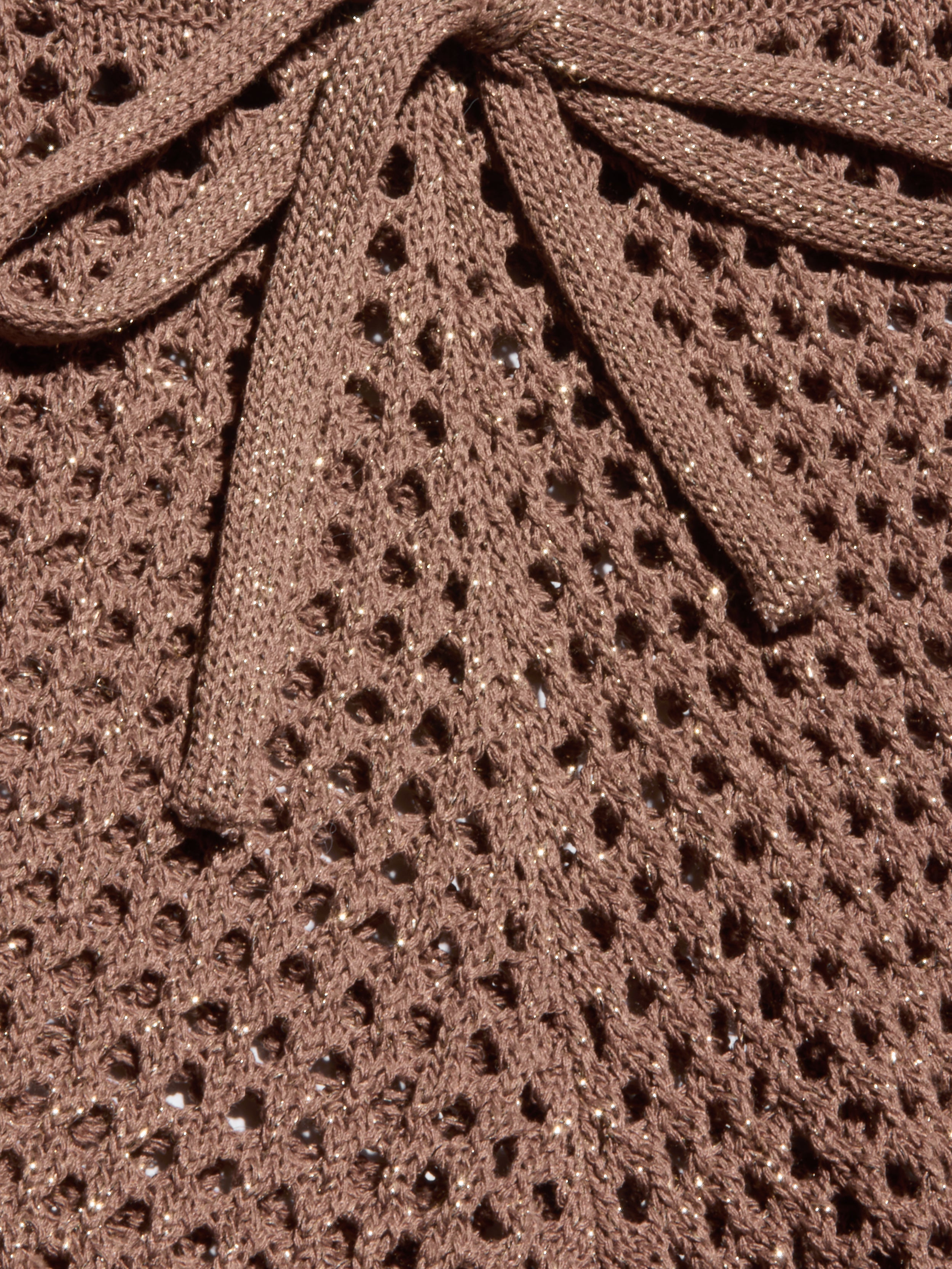 Close-up of the Solan Pointelle Knit Short in brown, featuring a glittery, net-like pointelle knit with shimmering threads woven throughout and a matching bow tied at the top center.