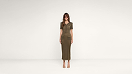 Woman standing against a plain white background, wearing sunglasses and a short-sleeved, olive green, button-front, midi-length dress with front pockets, and beige open-toe heels.