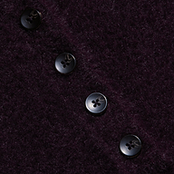 Four black buttons in a diagonal line accent the plush, dark purple knit of the Cirrus Cropped Polo, resting on its textured, fuzzy fabric background.