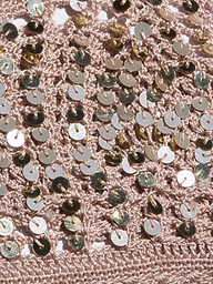 Close-up of the Taline Crocheted Bralette in pink, featuring textured crochet fabric adorned with shiny gold sequins that create a sparkly, eye-catching pattern across the surface.