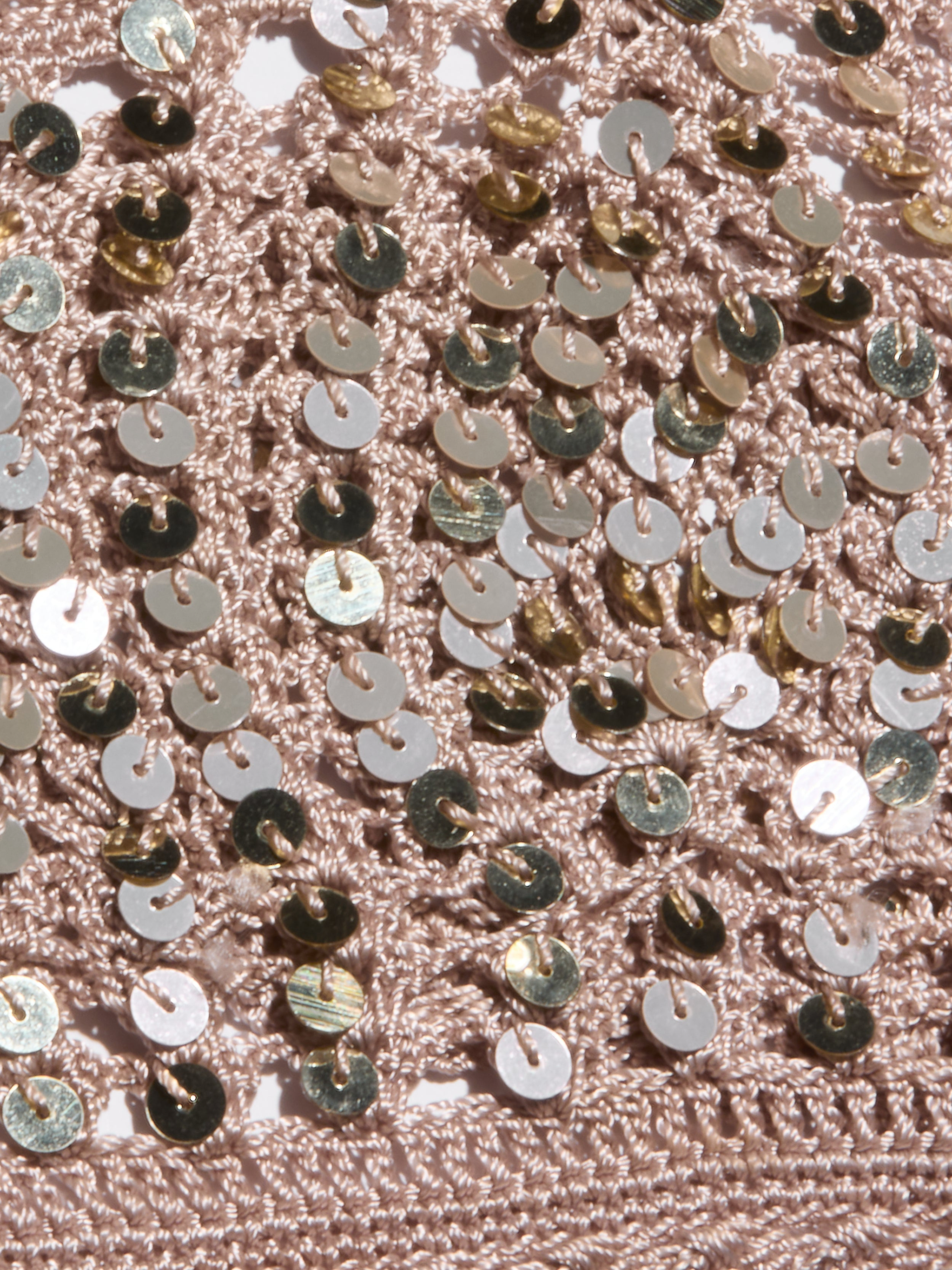 Close-up of the Taline Crocheted Bralette in pink, featuring textured crochet fabric adorned with shiny gold sequins that create a sparkly, eye-catching pattern across the surface.