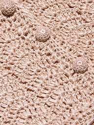Close-up of the Fey Crocheted Top in beige, featuring textured crochet fabric and three round, raised crochet buttons aligned diagonally across the surface, highlighting the handmade artistry of this piece.