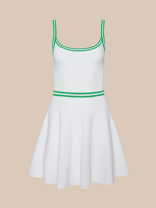 The Lilibet Knit Tennis Dress is a sleeveless white tennis dress highlighted by green trim along the neckline, straps, and waist. It features a fitted bodice and flared skirt crafted from professional-grade sport fabric, shown against a plain beige background.