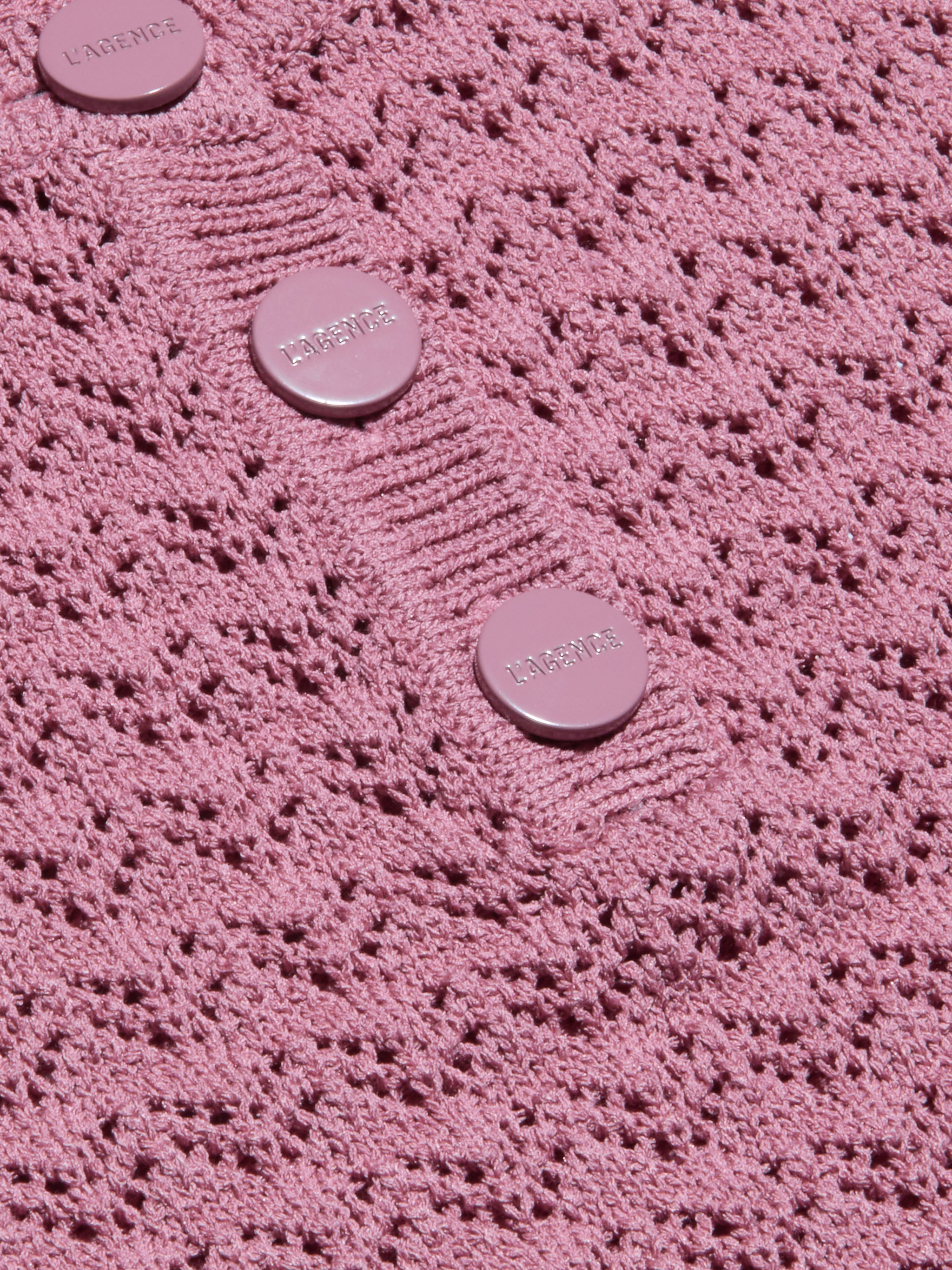 Primo piano del tessuto a maglia pointelle rosa testurizzato del Carven Pointelle Knit Tank, con tre bottoni rotondi rosa chiaro incisi a LAVERNE cuciti in fila su una sezione a coste.