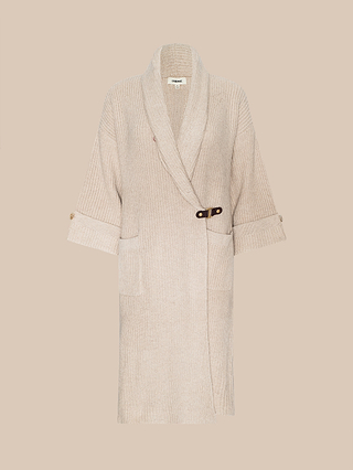 The Orielle Cardigan—a long beige knit sweater featuring a shawl collar, buttoned cuffs, front pockets, and a side buckle closure—makes the ideal fall wardrobe staple, shown here on a simple light beige background.