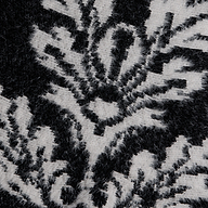 Close-up of the black and white fuzzy knit fabric of the Naiad Jacquard Fringe Cardigan, featuring a relaxed-fit floral pattern.