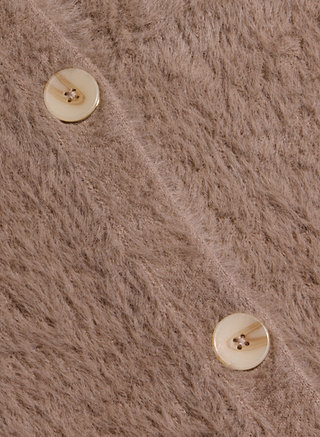 Close-up of the soft, fuzzy brown fabric of the Mist Cardigan, featuring two beige buttons with four holes each and a subtle marbled pattern. The image showcases the cozy texture of the cardigan and highlights the neat stitching around the buttons.