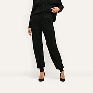 Black Tamaris Cable Knit Pant featuring a high, ribbed elastic waistband and cuffed ankles, styled as a slim-fit jogger with black pointed-toe heels.