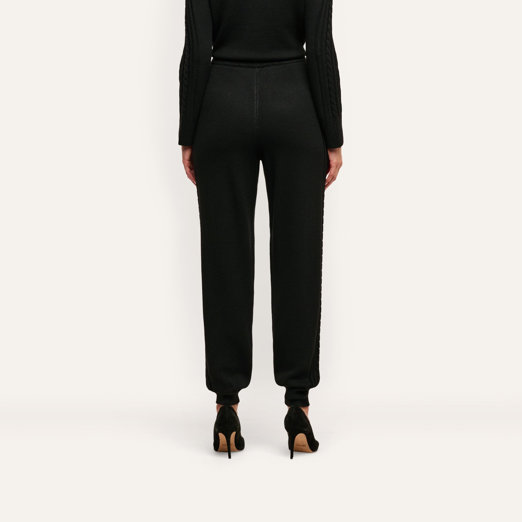 Back view of Tamaris Cable Knit Pant, featuring a soft slim-fit design with ribbed cuffs, worn with black high-heeled shoes.