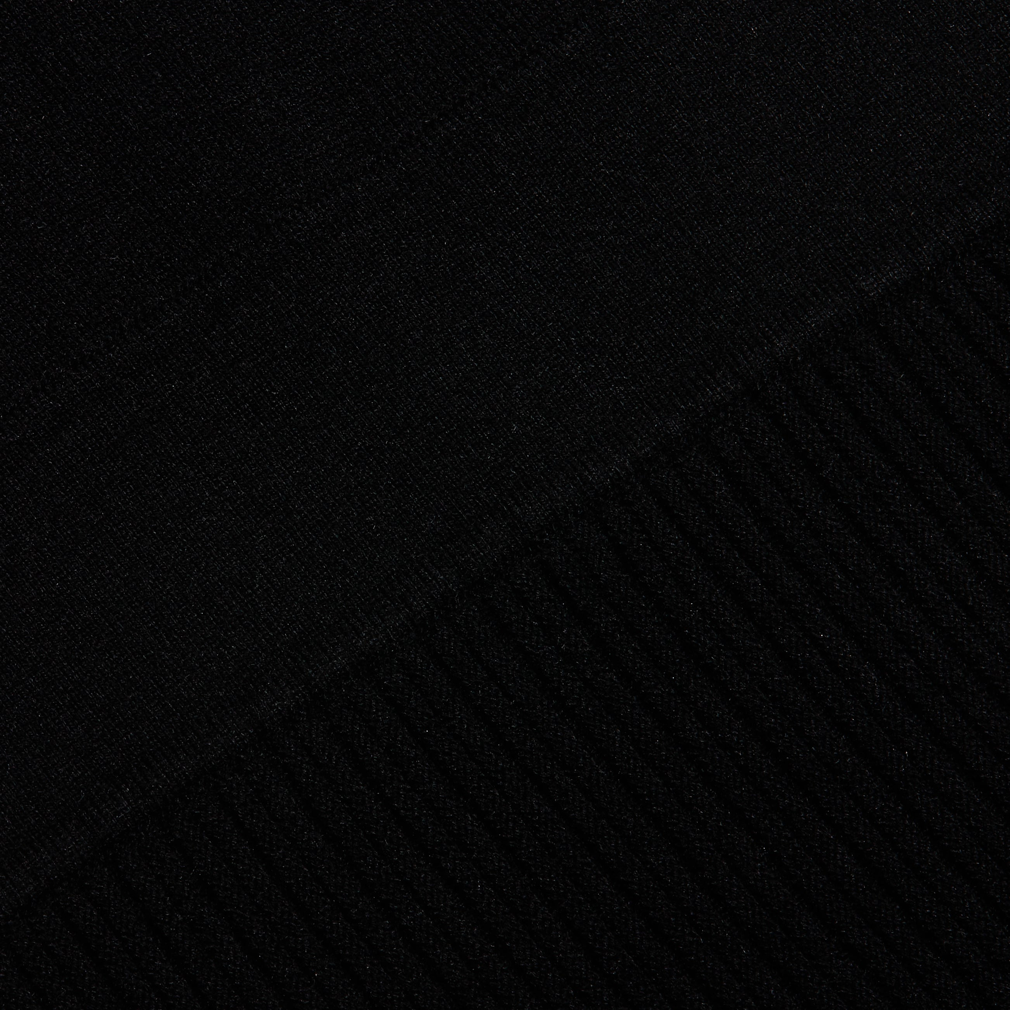 Close-up of the black Solaire Knit Dress, showing the transition from smooth knit fabric to a ribbed pattern.