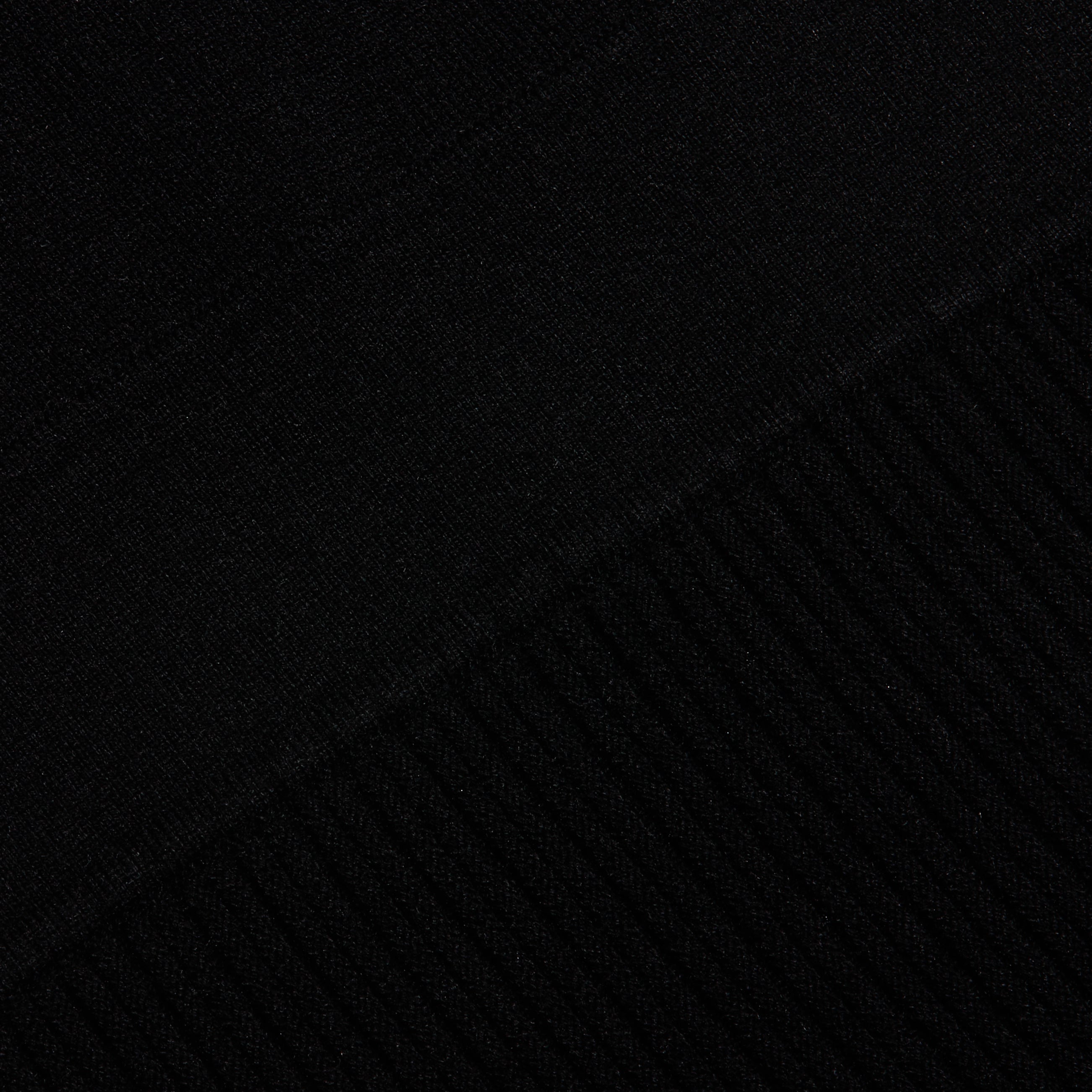 Close-up of the black Solaire Knit Dress, showing the transition from smooth knit fabric to a ribbed pattern.