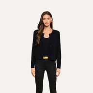 A woman with long brown hair wears the Malone Cashmere Cardigan in black over a matching top and black pants, standing against a plain light background.