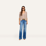 A woman stands against a plain white background, wearing sunglasses, the Malone Cashmere Cardigan over a tank top, wide-leg blue jeans, and brown shoes.