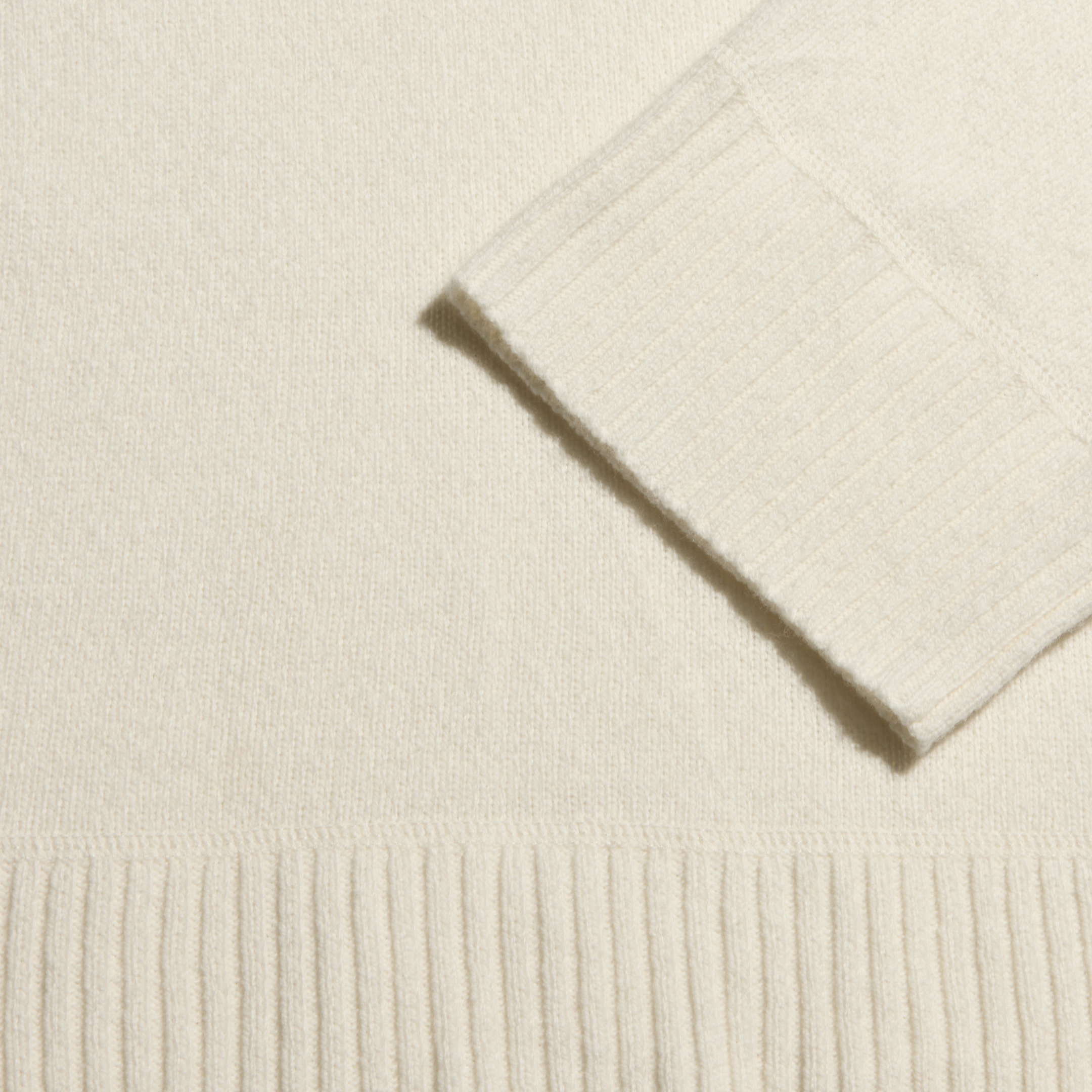 Selwyn Oversized Turtleneck in ivory with a ribbed cuff and hem.