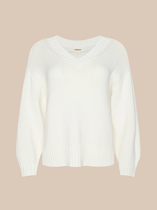 The Paxton Oversized Pullover, a white cotton v-neck sweater featuring ribbed cuffs and hem, is displayed on a plain beige background and offers a classic look perfect for layering.