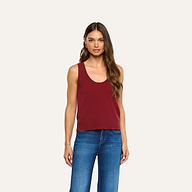 A woman wears a maroon Filou Cashmere Tank with a scoop neckline paired with blue jeans.