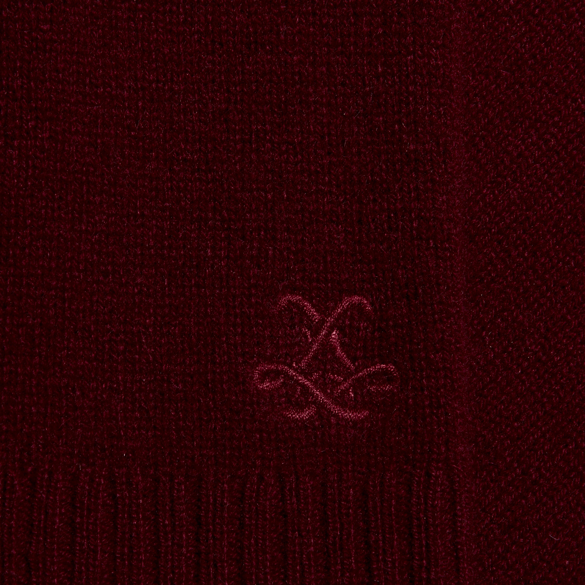Close-up of a deep red lightweight Filou Cashmere Tank featuring an embroidered monogram logo.