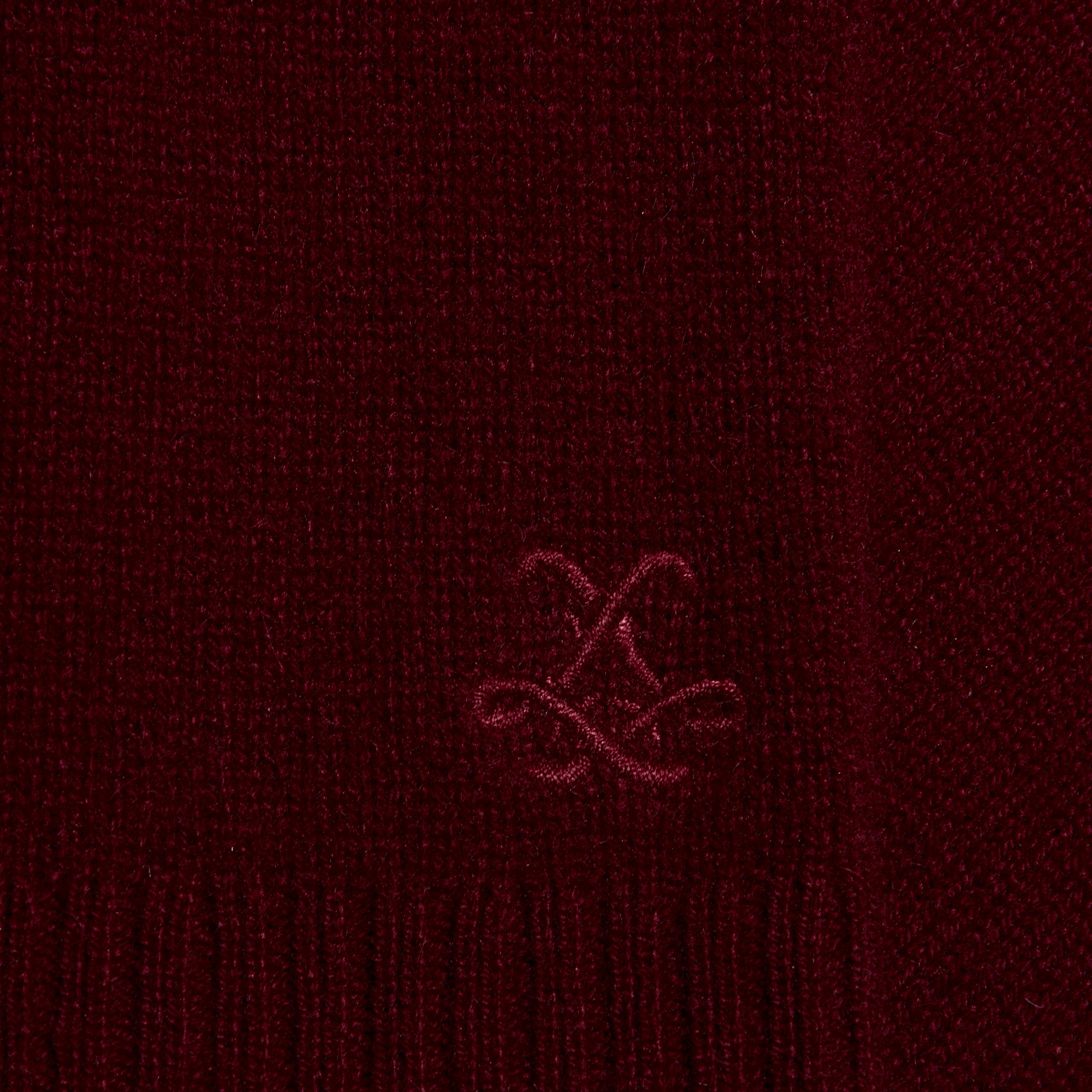 Close-up of a deep red lightweight Filou Cashmere Tank featuring an embroidered monogram logo.