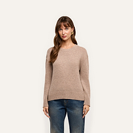 A woman wearing a relaxed-fit tan Laine Cashmere Pullover and blue jeans.