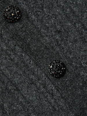 Close-up of the Talulla Cardigan by L'AGENCE: a dark gray, textured knit design with two round black jeweled buttons adorned with shiny embellishments. The soft knitted fabric adds to its luxe appeal.