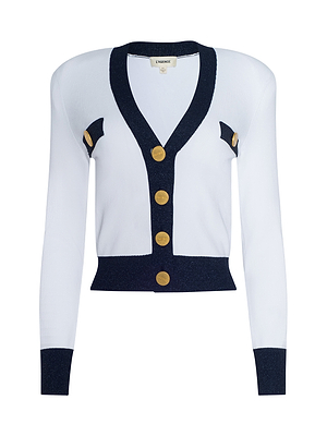 The Taya Cardigan is a Parisian-inspired white cardigan with black accents, metallic trim, gold buttons, and a fitted cropped style. Chic black details on the cuffs, hem, neckline, and chest add an elegant touch.