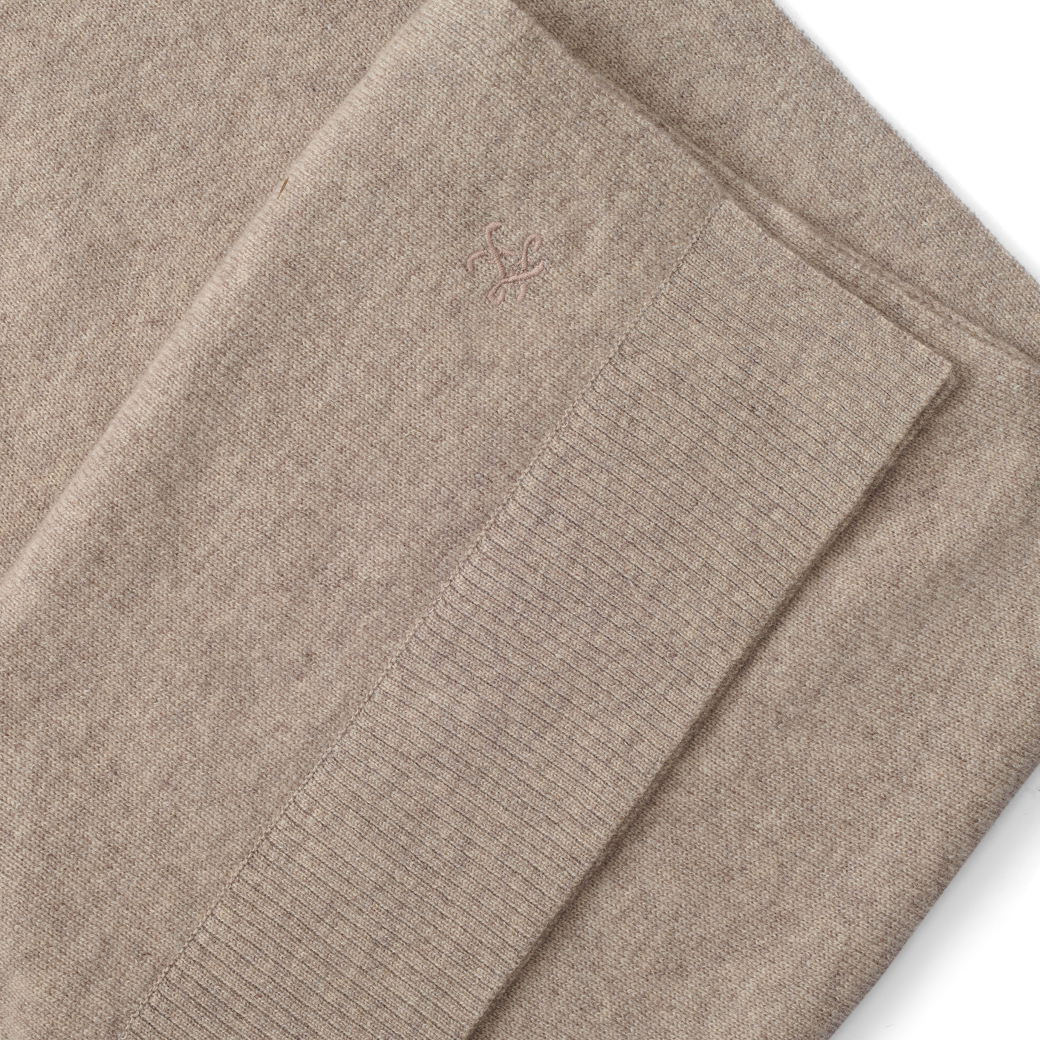 Palais Cashmere Scarf in tan, featuring a folded pebbled texture, a ribbed hem, and a small embroidered emblem.