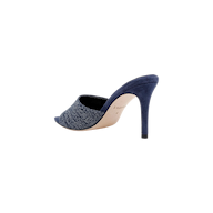 The Lolita Denim Open-Toe Mule, featuring a denim upper and a blue suede stiletto heel, is shown from the side and slightly behind against a white background.