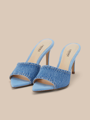 The Lolita Denim Open-Toe Mule features light blue denim uppers, tan insoles with comfy memory foam cushions, and is shown on a neutral beige background.
