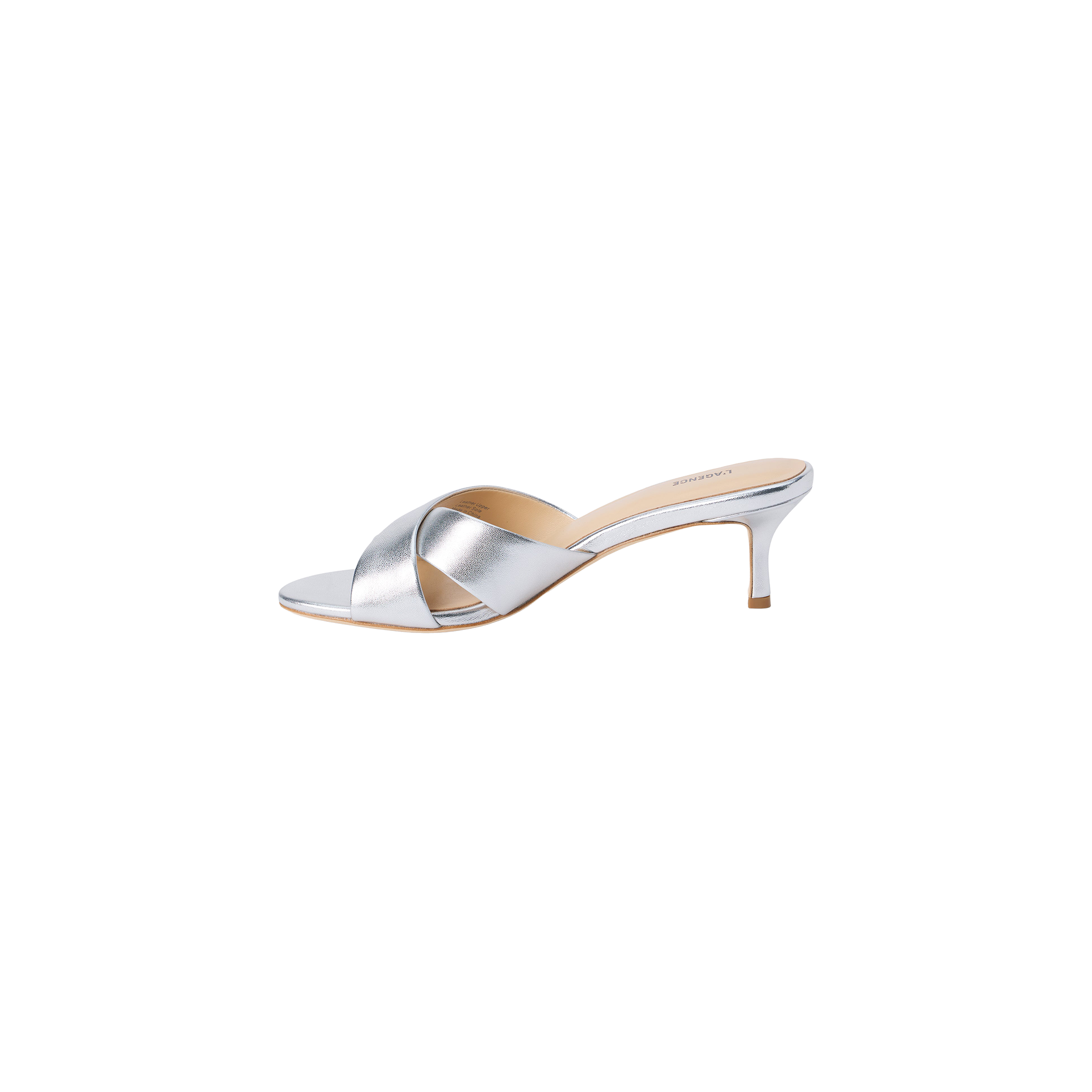 Aveline Kitten-Heel Sandal in silver metallic leather showcases a low kitten heel, open toe, and wide crisscross straps, displayed on a white background.